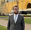 Man in suit standing in front of the Palace of Westminster in London