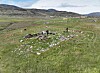 Steinlagt område markert med rødt bånd i et grønt fjellandskap.