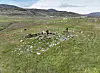 Steinlagt område markert med rødt bånd i et grønt fjellandskap.