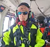 Redningsarbeider i synlighetsklær og hjelm sitter inne i et luftfartøy.