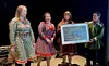 Sametingspresident Silje Karine Muotka (andre t.v.) og Sandra Márjá West, politisk rådgiver for sametingsrådet (ytterst t.v.), var til stede på åpningen av Samisk hus i Tromsø/Romssa Sámi Viessu. Her overrekker de en gave fra Sametinget til huset ved daglig leder Jill Abelsen Olsen og styreleder Torjer Olsen. Dette er et fotografi fra den gamle samiske sommerboplassen i Romsavággi/Tromsdalen fra rundt år 1920. Bildet er tilrettelagt av den samiske kunstneren Hans Ragnar Mathisen. (Foto: Sametinget)